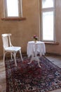 White table with lace tablecloth and Viennese chair on the rug in the old room Royalty Free Stock Photo