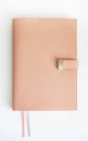 On a white table lies a pink leather-bound notebook. Royalty Free Stock Photo