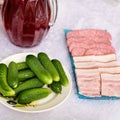 On a white table lies a snack for vodka, in the form of fresh cucumbers