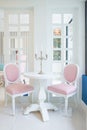 White table and pink chair with candle on table in living room