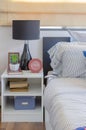 White table with plant in vase on book and black lamp in bedroom