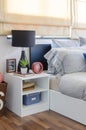 White table with plant in vase on book and black lamp in bedroom