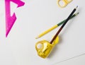 on a white table a ruler and scissors with a black pencil inserted into a yellow sharpener on a white sheet. Royalty Free Stock Photo