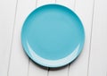 White table setting from above. Empty blue plate on planked wood . Royalty Free Stock Photo