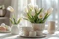 a white table with tulips, eggs and cups in it Royalty Free Stock Photo