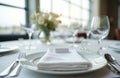 White tablecloth with elegant dinner setting. White plate, napkin, silverware, wine glass on table. Formal dining setup in fancy Royalty Free Stock Photo