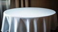Round table with white tablecloth, copy space, elegant background draped curtains Royalty Free Stock Photo