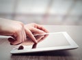 White tablet with a blank screen in the hands on table