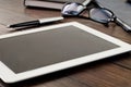 White tablet computer on office wooden table closeup