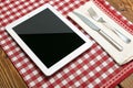 Tablet PC with Fork and Knife on Red Checked Tablecloth Ã¢â¬\' Modern Dining Concept Royalty Free Stock Photo