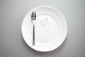 White tablet pill medical drug on plate with fork for food and h