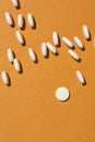 White tablet pills on orange background