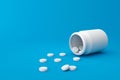 White tablets of many painkillers with a pharmacy bottle on a medical background. White pills for alleviating illness or fever. 3D
