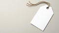 A white tag is suspended from a stack of cardboard boxes featuring a brown texture, set against a soft beige background Royalty Free Stock Photo
