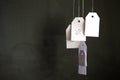 White tags with the percent sign hang on strings on a black background with shadows. Commerce, discount, sale, trade offer. Copy Royalty Free Stock Photo