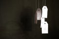 White tags with the percent sign hang on strings on a black background with shadows. Commerce, discount, sale, trade offer. Copy Royalty Free Stock Photo