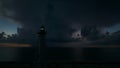 White tall lighthouse on sea shore with blinking light at stormy night for commercial vessels navigation. Thunderstorm