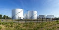 white tanks in tank farm with iron staircase