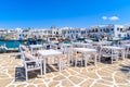White tavern tables in Naoussa port with fishing boats, Paros island, Greece Royalty Free Stock Photo