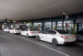 White taxi cars like BMW and Mercedes in front of the Flughafen Wien-Schwechat airport