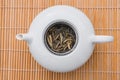 White tea bud leaves steeping in a beautiful white porcelaine teapot