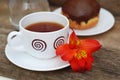 White Tea Cup Chocolate Donut Orange Red Flower Alstromeria Astromeria over Rustic Wooden Background. Copy space Royalty Free Stock Photo