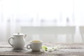 White tea cup and tea pot and flowers on wooden table minimal interior Royalty Free Stock Photo