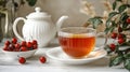 White tea cup with a red leaf on the side sits on a white plate Royalty Free Stock Photo