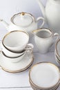 White tea set on a white background. Teapot, cream, sugar bowl, cups, saucers, plates on the table. Royalty Free Stock Photo