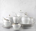 White tea set on a white background. Teapot, cream, sugar bowl, cups, saucers, plates on the table. Royalty Free Stock Photo