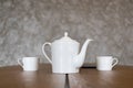 white tea set teapot and two cups stand on a brown table Royalty Free Stock Photo