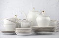 White tea set on a white background. Teapot, cream, sugar bowl, cups, saucers, plates on the table. Royalty Free Stock Photo