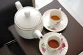 White Teacup and teapot on brown chair Royalty Free Stock Photo