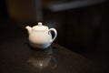 White teapot for brewing tea on a black stock photo