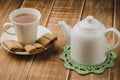 white teapot and cup of tea with cookies/white teapot and cup of Royalty Free Stock Photo