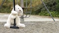 White teddy bear, doing the zip line, in the middle of nature Royalty Free Stock Photo