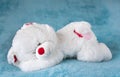 White teddy bear sleeping on the bed