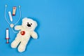 White teddy bear with toy stethoscope and toy medicine tools on a light blue background. Top view. Copy space for text Royalty Free Stock Photo