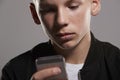 White teenage boy using mobile phone, close up, horizontal Royalty Free Stock Photo