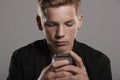 White teenage boy using mobile phone, head and shoulders Royalty Free Stock Photo