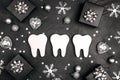 White teeth with silver decorations and gift boxes on black background. Dentist Merry Christmas and New Year concept