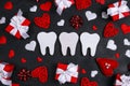 White teeth surrounded by gifts and hearts on a black background. Dental Valentine card.