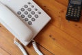 White telephone and black handy walkie talkie on wooden table Royalty Free Stock Photo