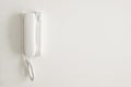 A white telephone hangs on a white wall Royalty Free Stock Photo