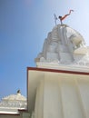 a white tempal in india with blue sky, and showing best stone art work.