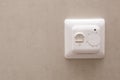 White temperature controller of a warm floor on a gray wall. Royalty Free Stock Photo