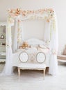 White tender bedroom with canopy wreathed