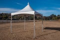 White tent in brown grass field under blue sky Royalty Free Stock Photo