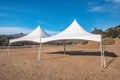 White tent in brown grass field under blue sky