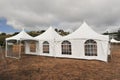 White tents in a dry field outdoors